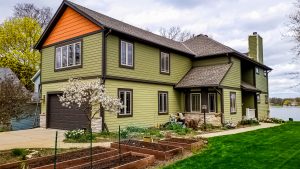 Exterior of a two-story home that has been painted green and orange