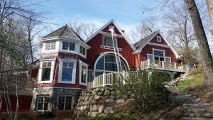 Exteior of a multi-level home that is being painted bright red